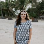 Woman wearing Carrie Short Dress on the beach in grey and white Ikat cotton.