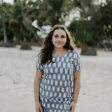 Woman wearing Carrie Short Dress on the beach in grey and white Ikat cotton.