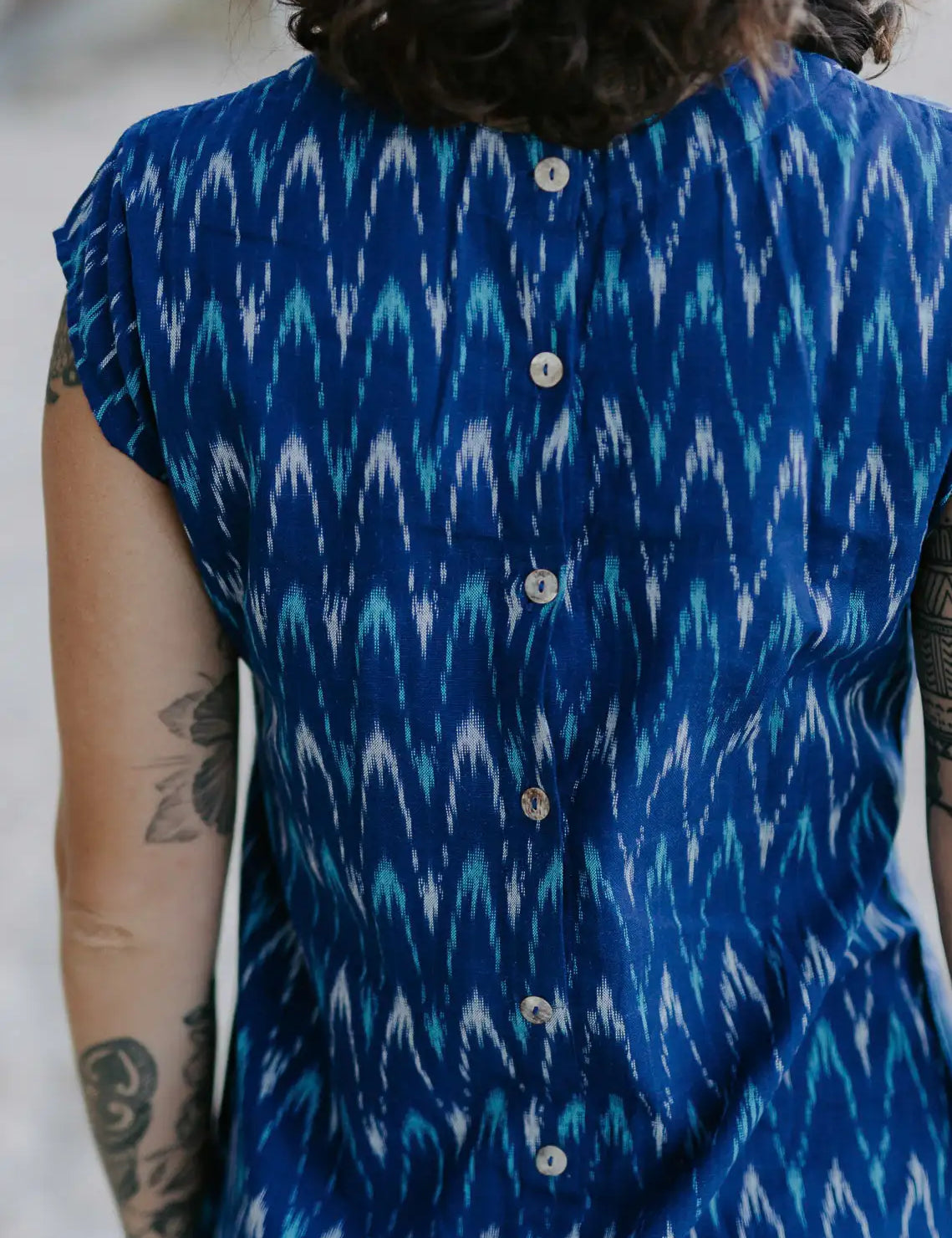 Woman wearing timeless shift dress with mother-of-pearl buttons and French seams