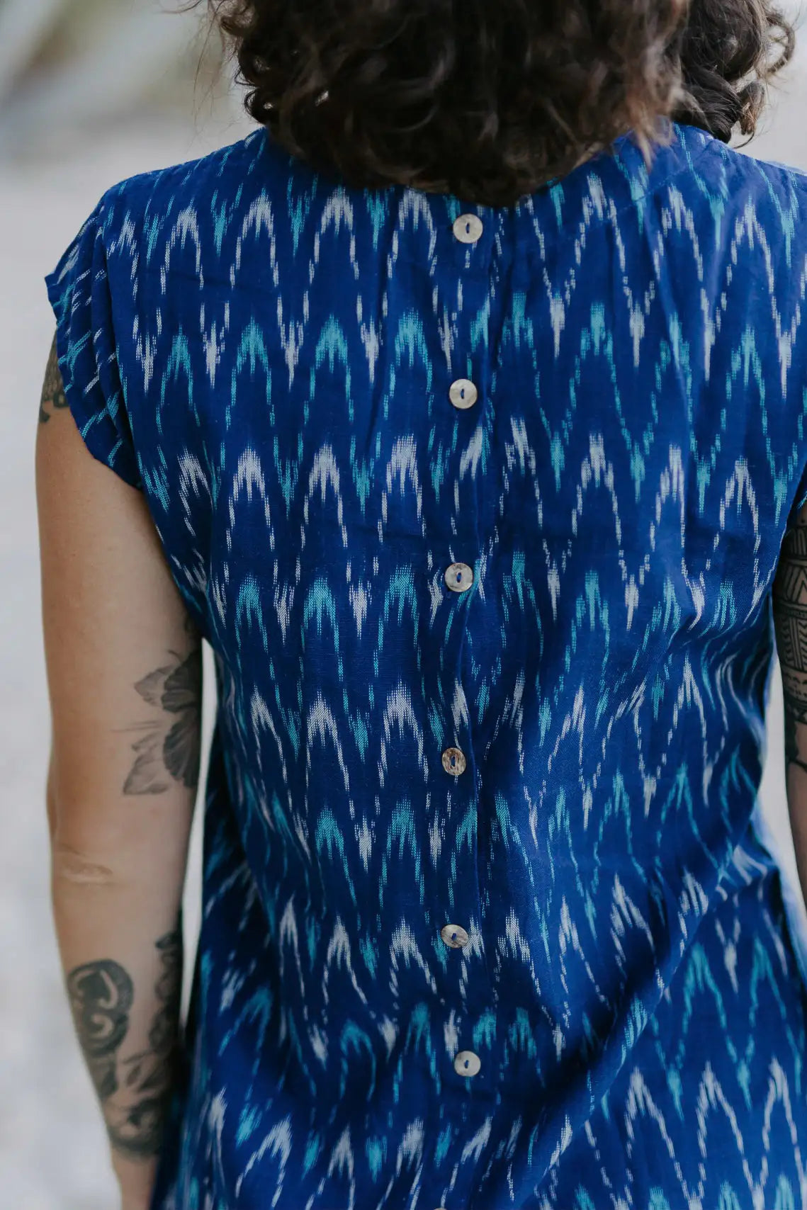 Woman wearing timeless shift dress with mother-of-pearl buttons and French seams